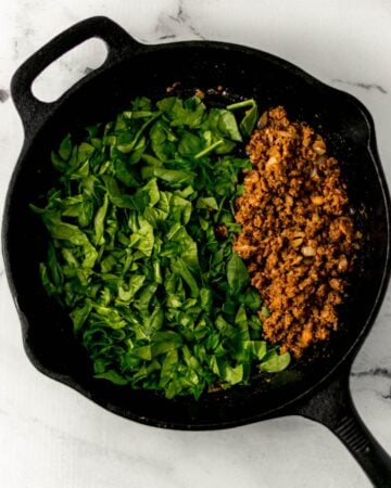 Chorizo and spinach in cast iron skillet.