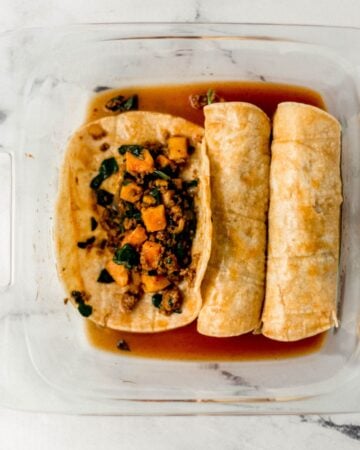 Enchiladas being prepared in a glass baking dish.