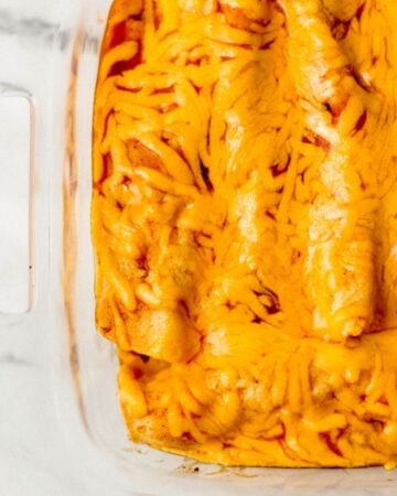 Baked enchiladas in glass baking dish.