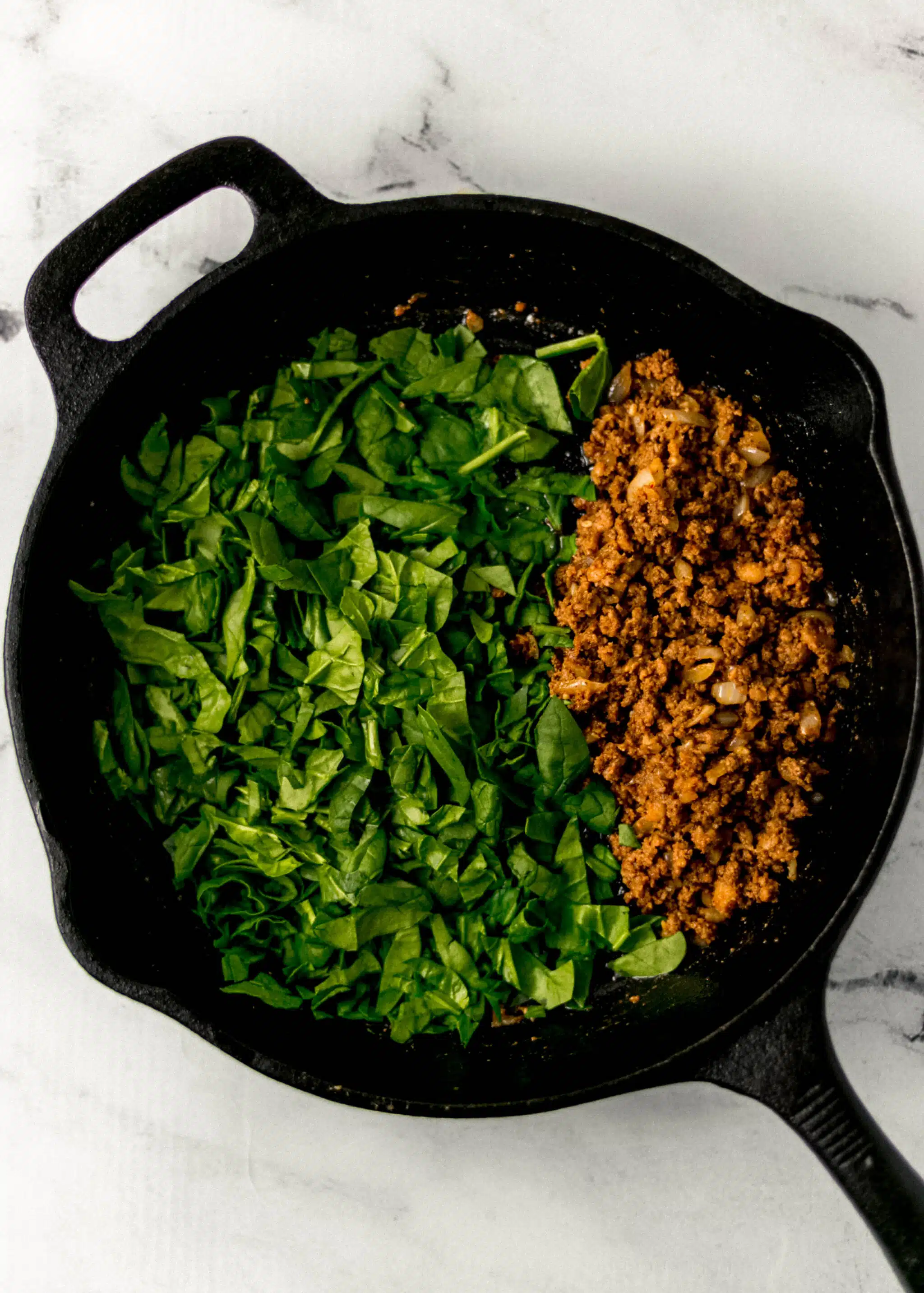 chorizo, onion, garlic, and spinach in cast iron skillet 