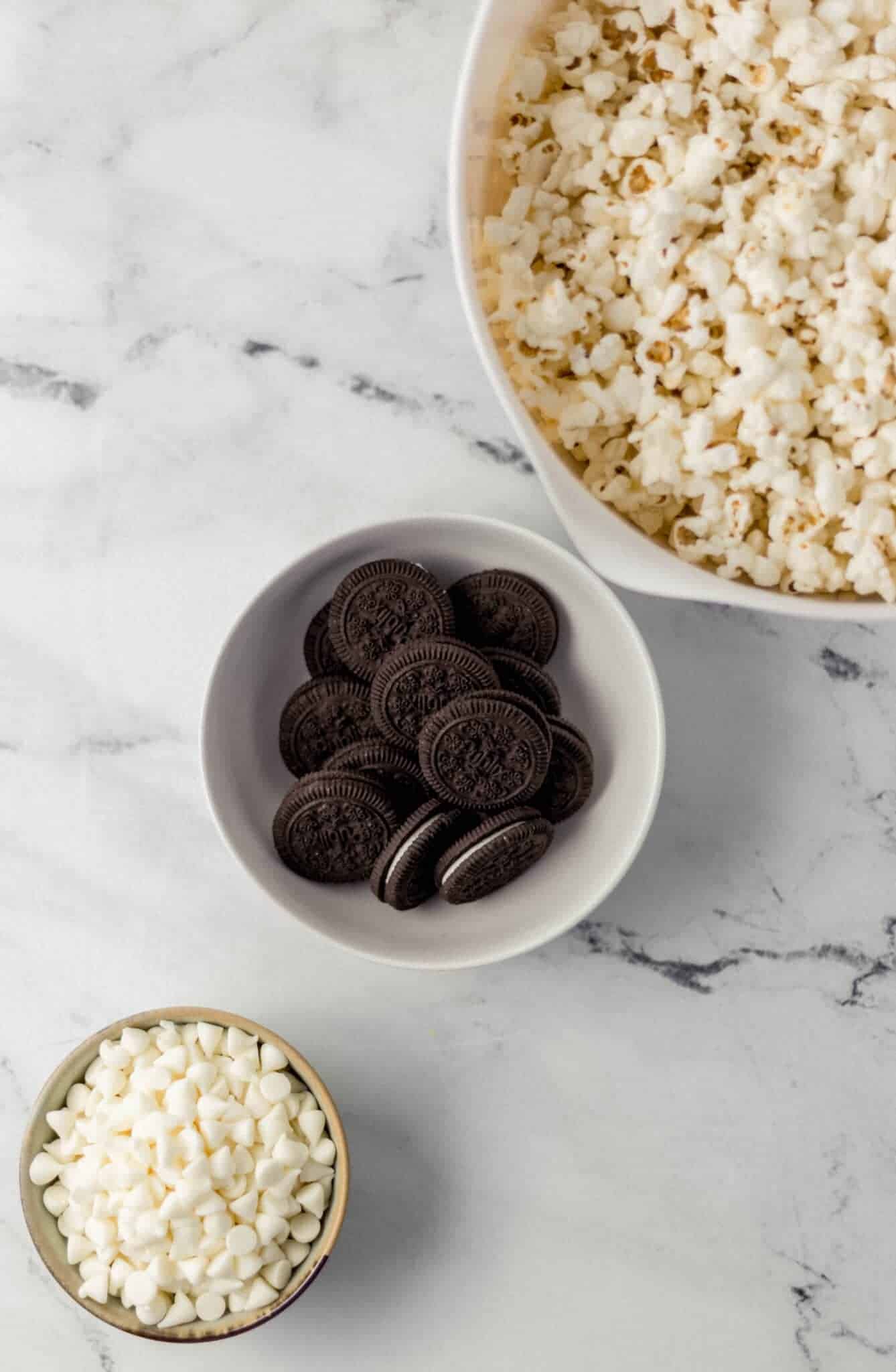 ingredients needed to make popcorn in three separate bowls 