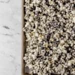 overhead view of finished cookies and cream popcorn on parchment lined baking sheet