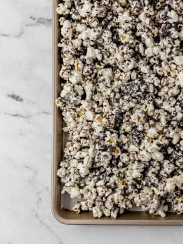 overhead view of finished cookies and cream popcorn on parchment lined baking sheet