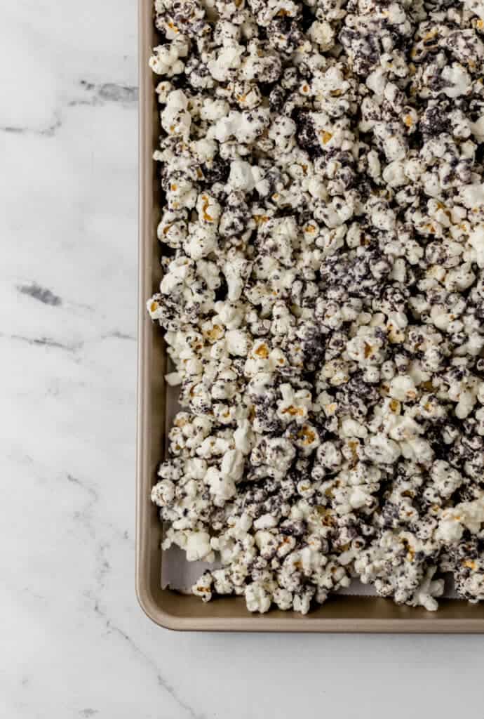 overhead view of finished cookies and cream popcorn on parchment lined baking sheet