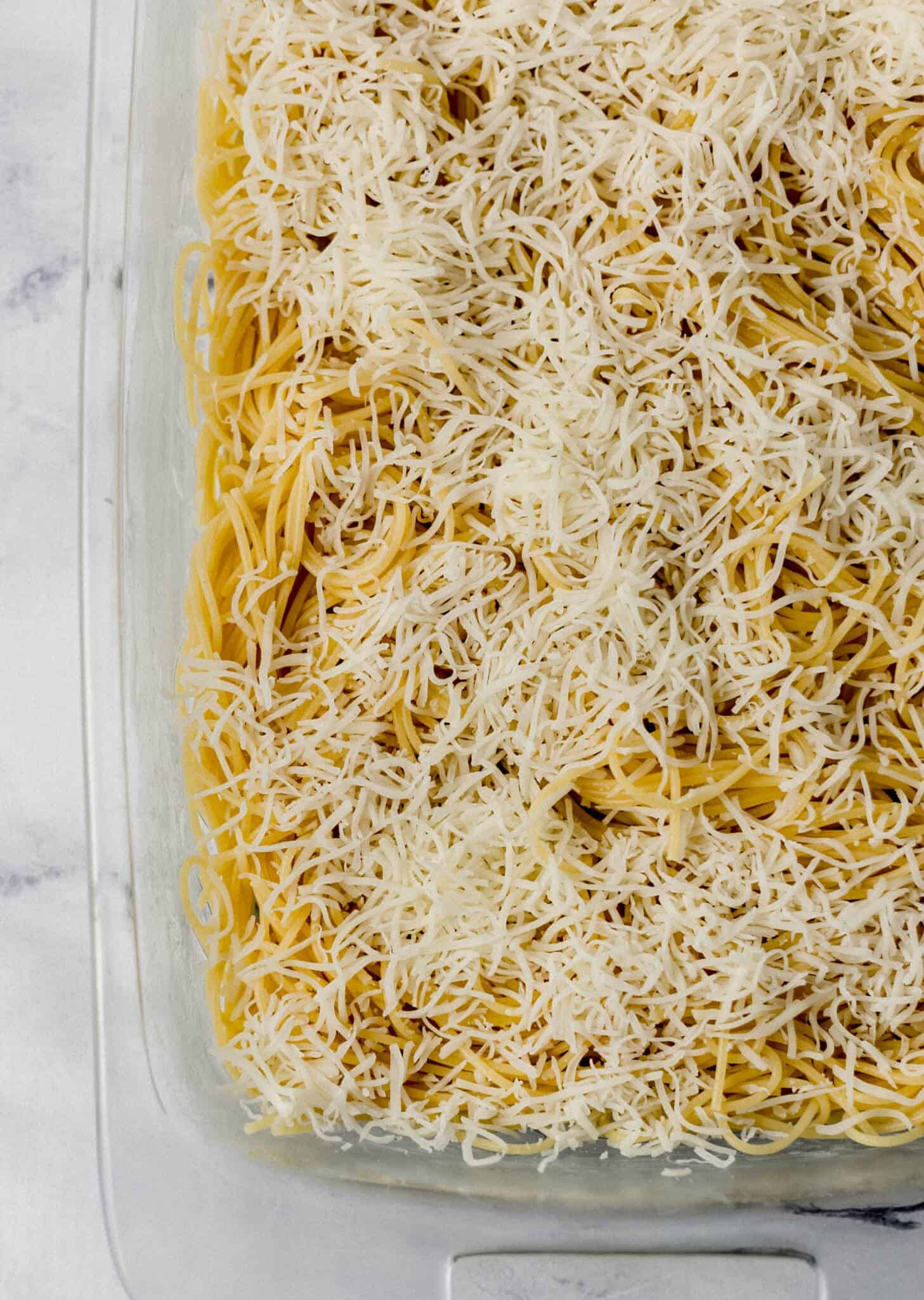 spaghetti and cheese in glass baking dish