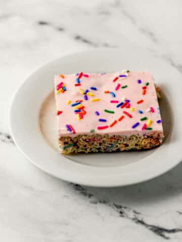 close up side view of single krispie treat on small white plate