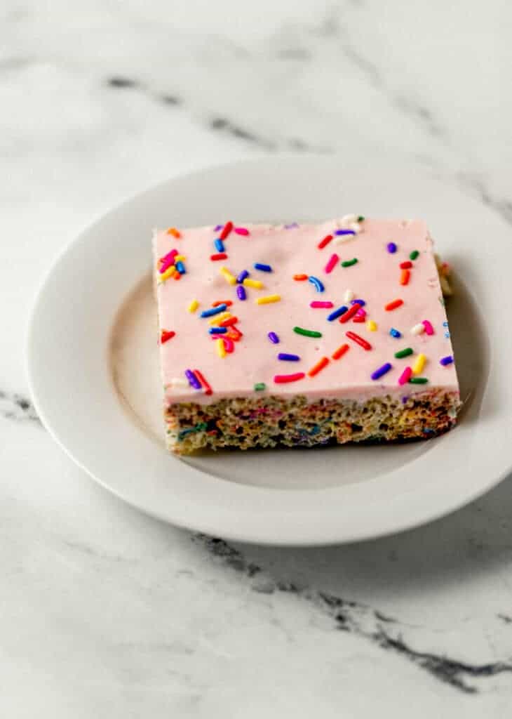 close up side view of single krispie treat on small white plate