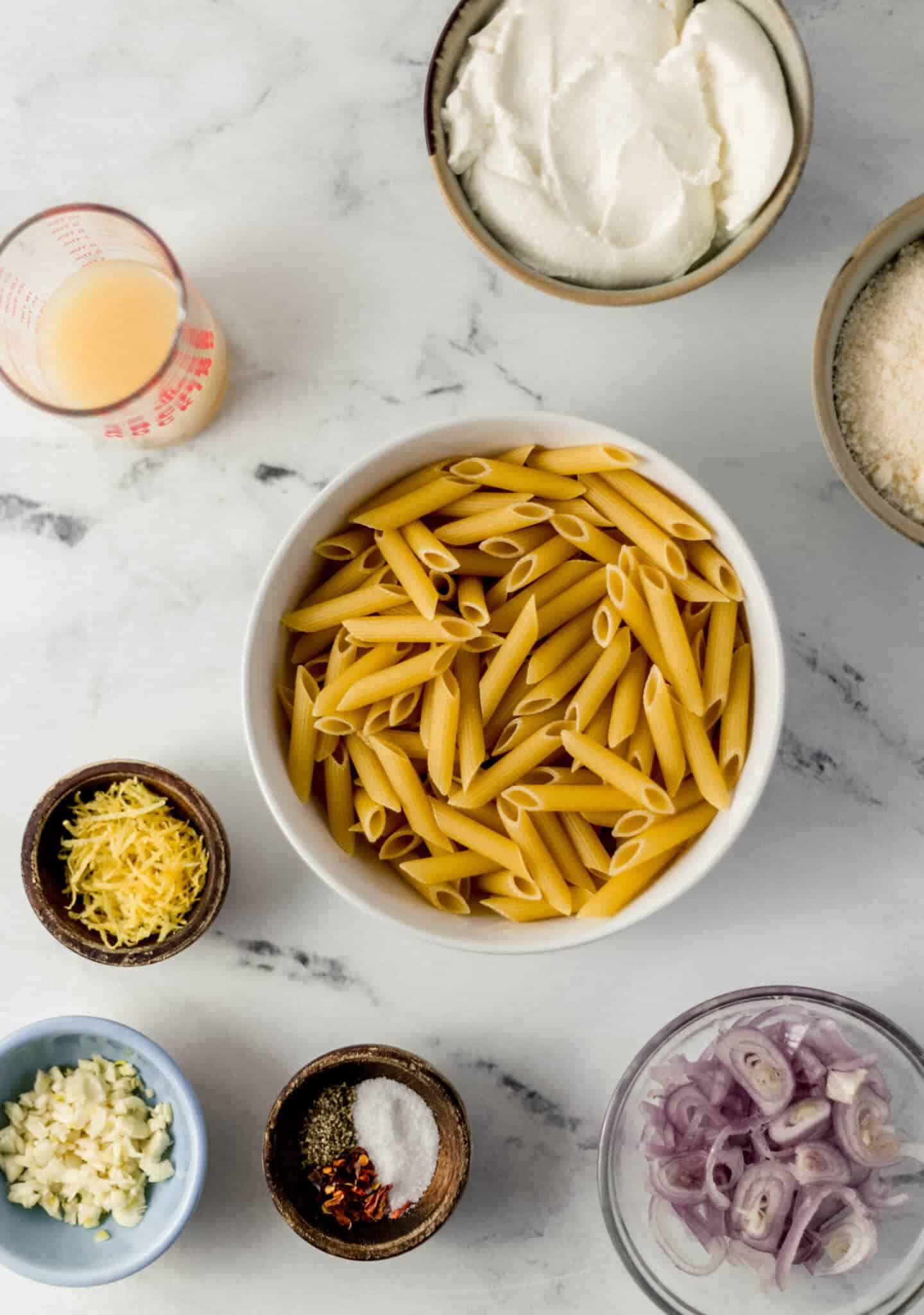 overhead view of ingredients needed to make pasta in separate bowls