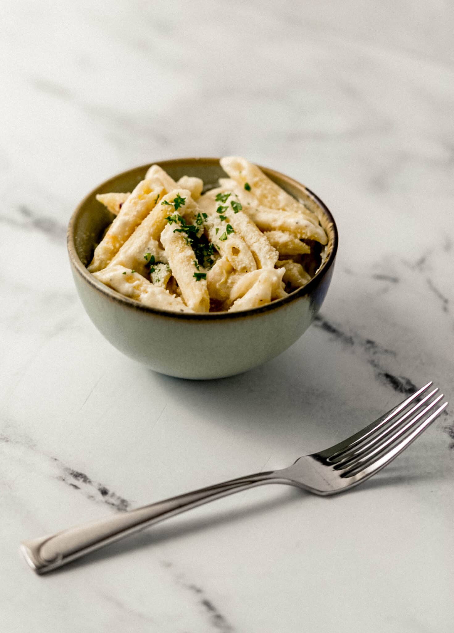 serving of pasta in a bowl beside a fork