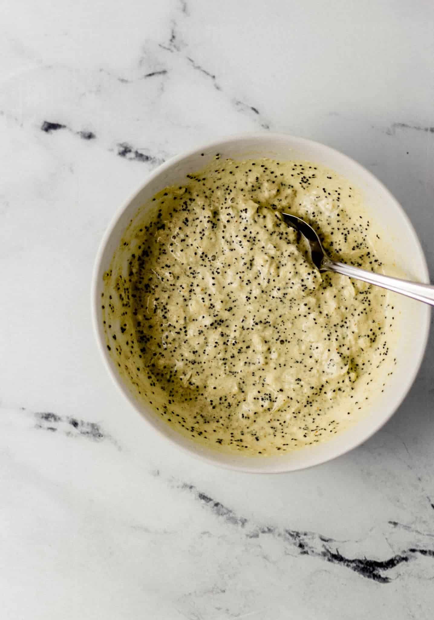 sauce ingredients combined together in small white bowl with spoon