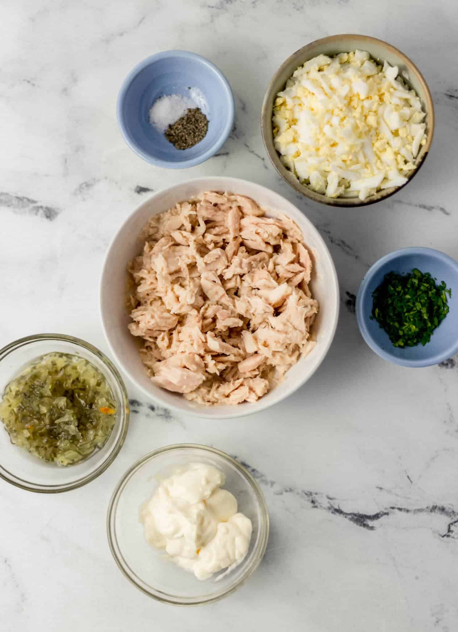ingredients needed to make tuna salad in separate bowls