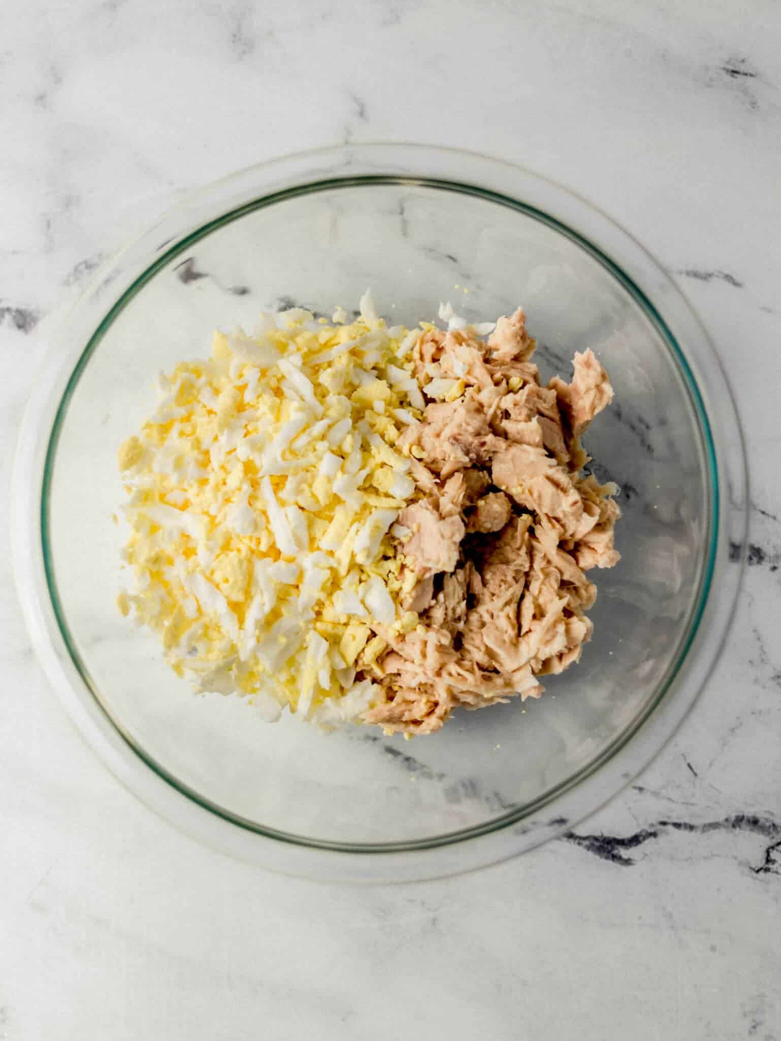 tuna and grated eggs added to glass mixing bowl