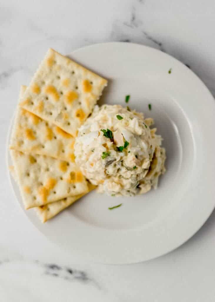 single serving of finished tuna salad on white plate with saltines