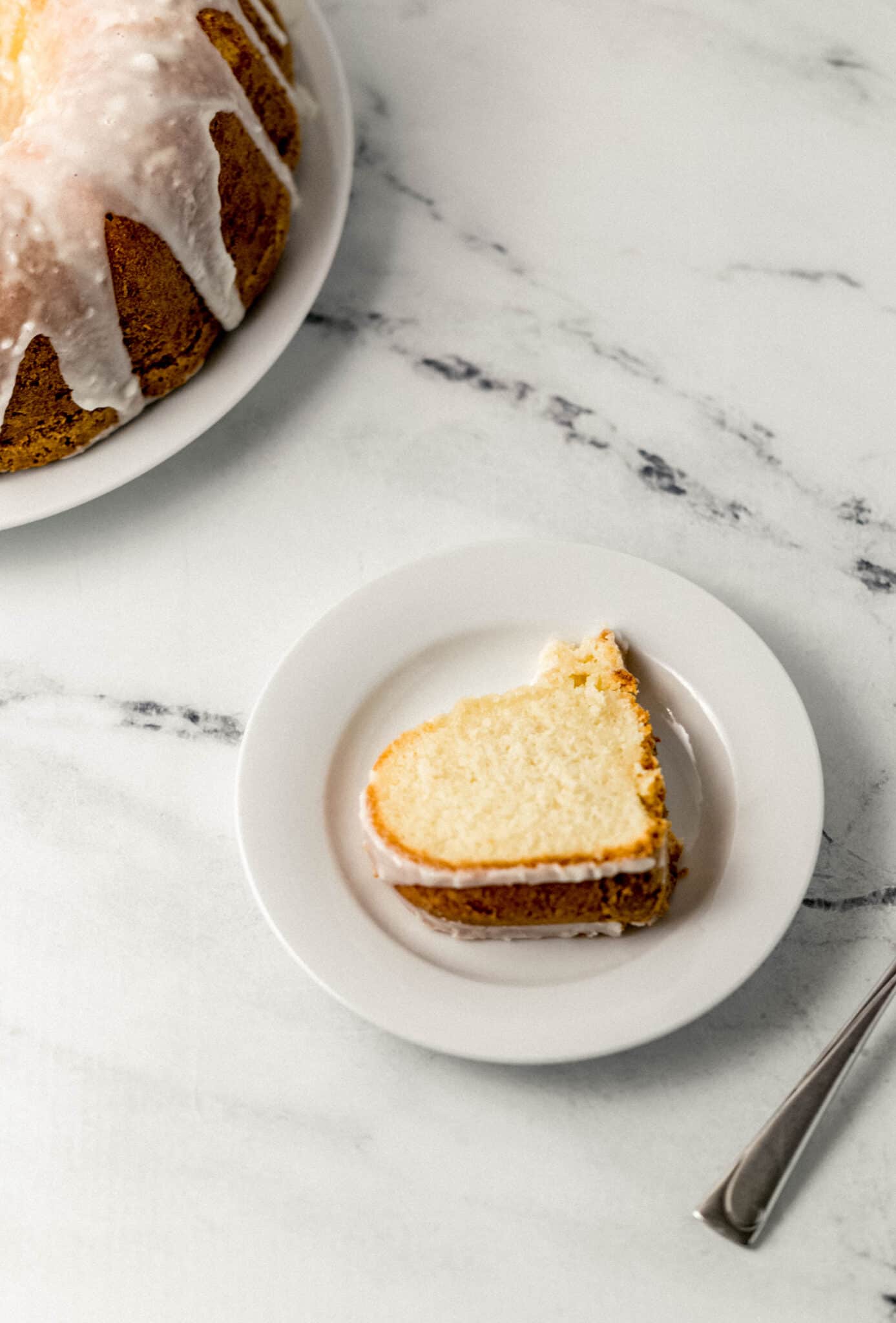 slice of sun drop cake on a small white plate by a fork and the rest of the cake