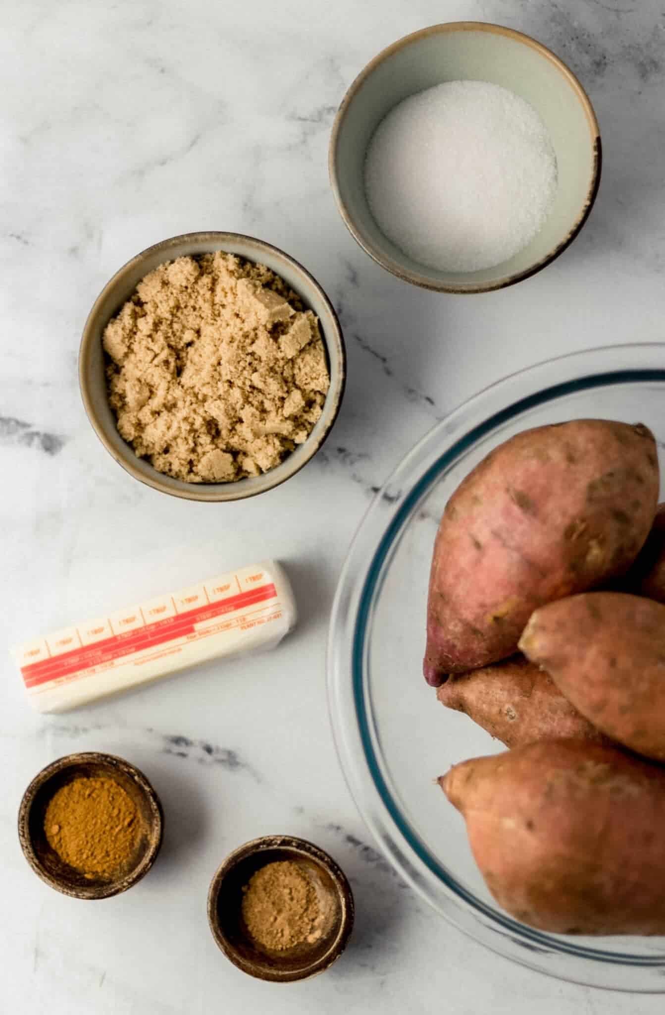overhead view of ingredients needed to make yams in separate bowls along with a stick of butter