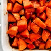 Close up view of finished yams in white baking dish.