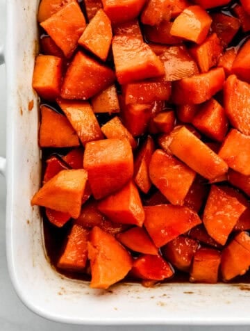 Close up view of finished yams in white baking dish.