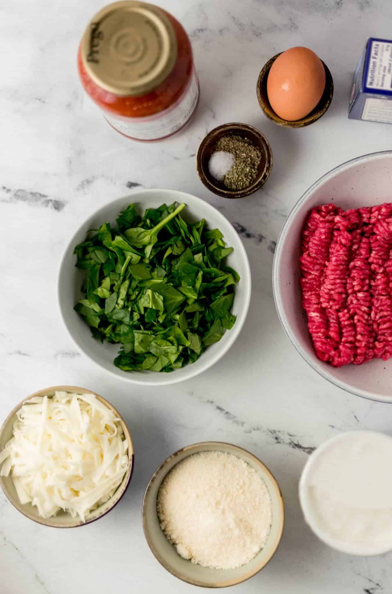 overhead view of ingredients needed to make lasagna in separate containers.