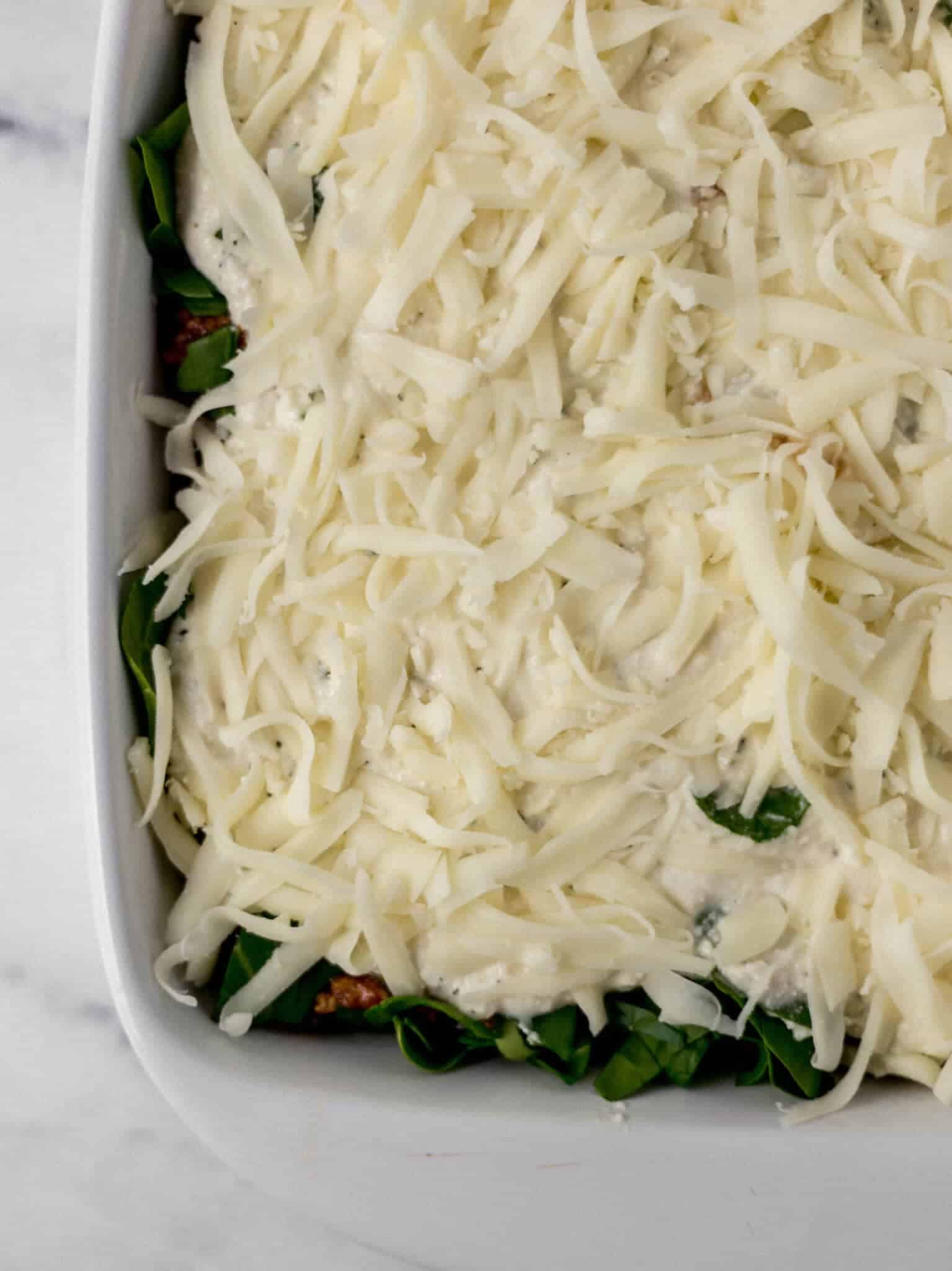 cheeses added to lasagna in baking dish before baking 