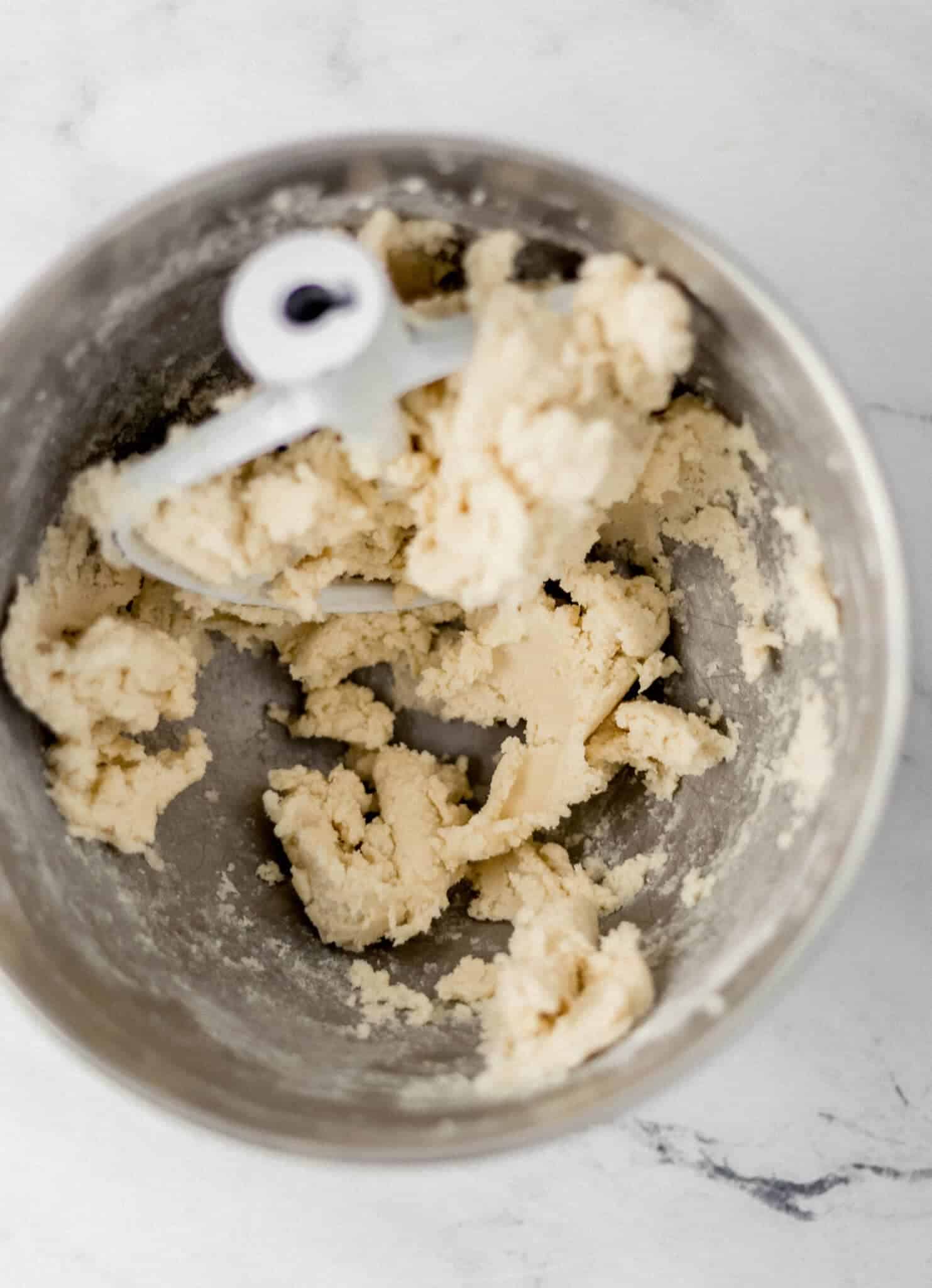 ingredients to make cookies mixed together in stand mixer bowl 