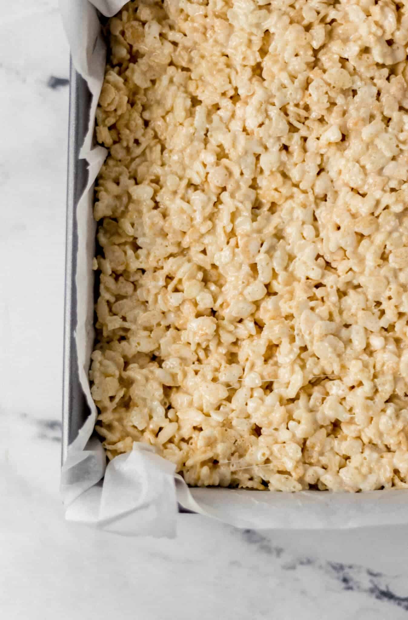rice crispy treats added to parchment lined baking pan 