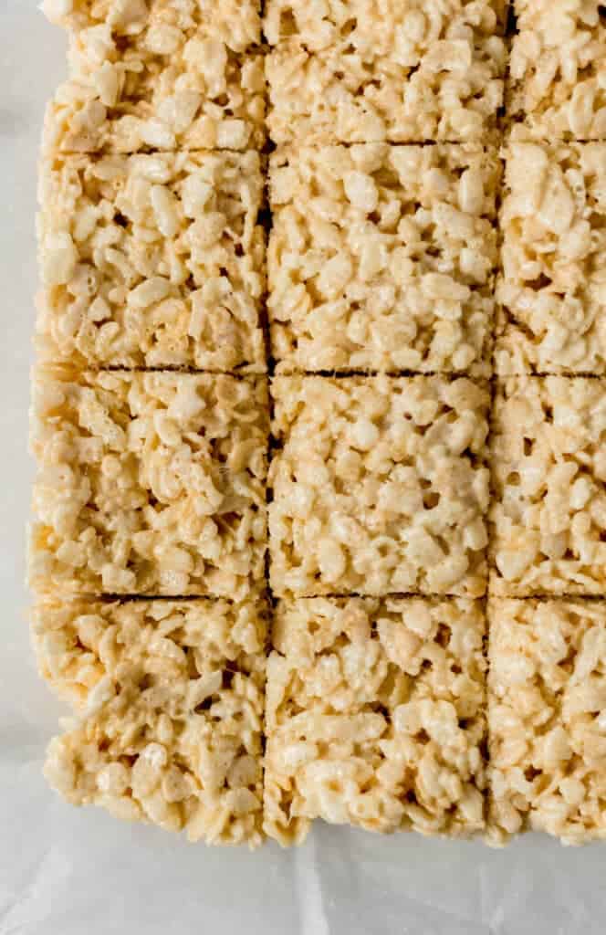 overhead view of crispy treats cut into squares on parchement paper