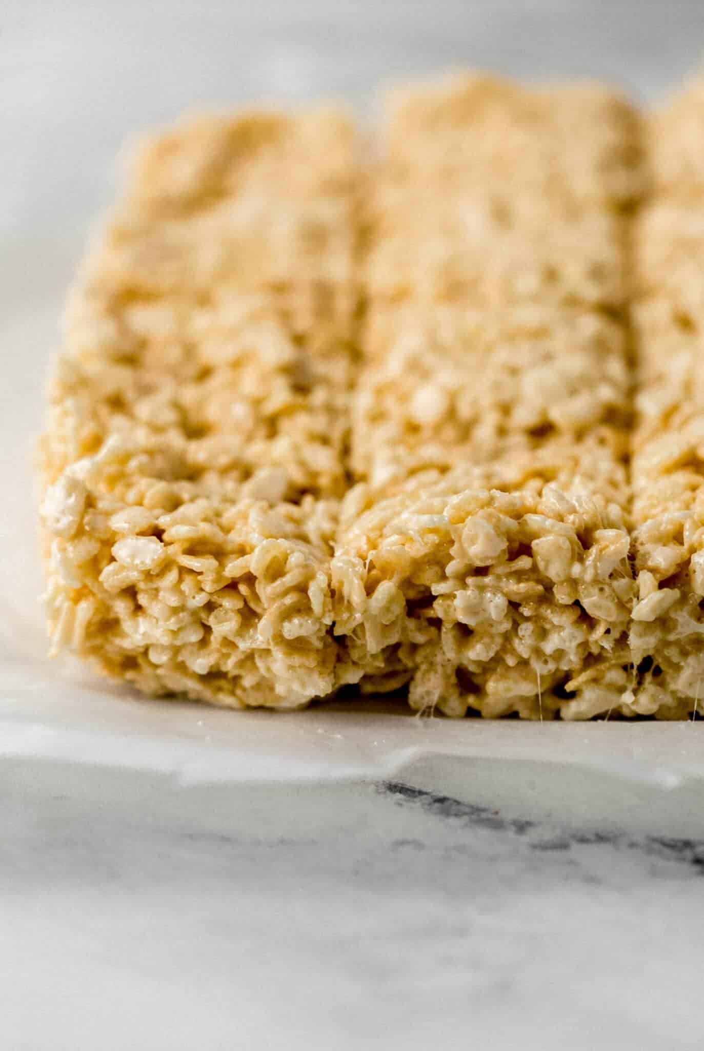 close up side view of crispy treats on parchment paper 
