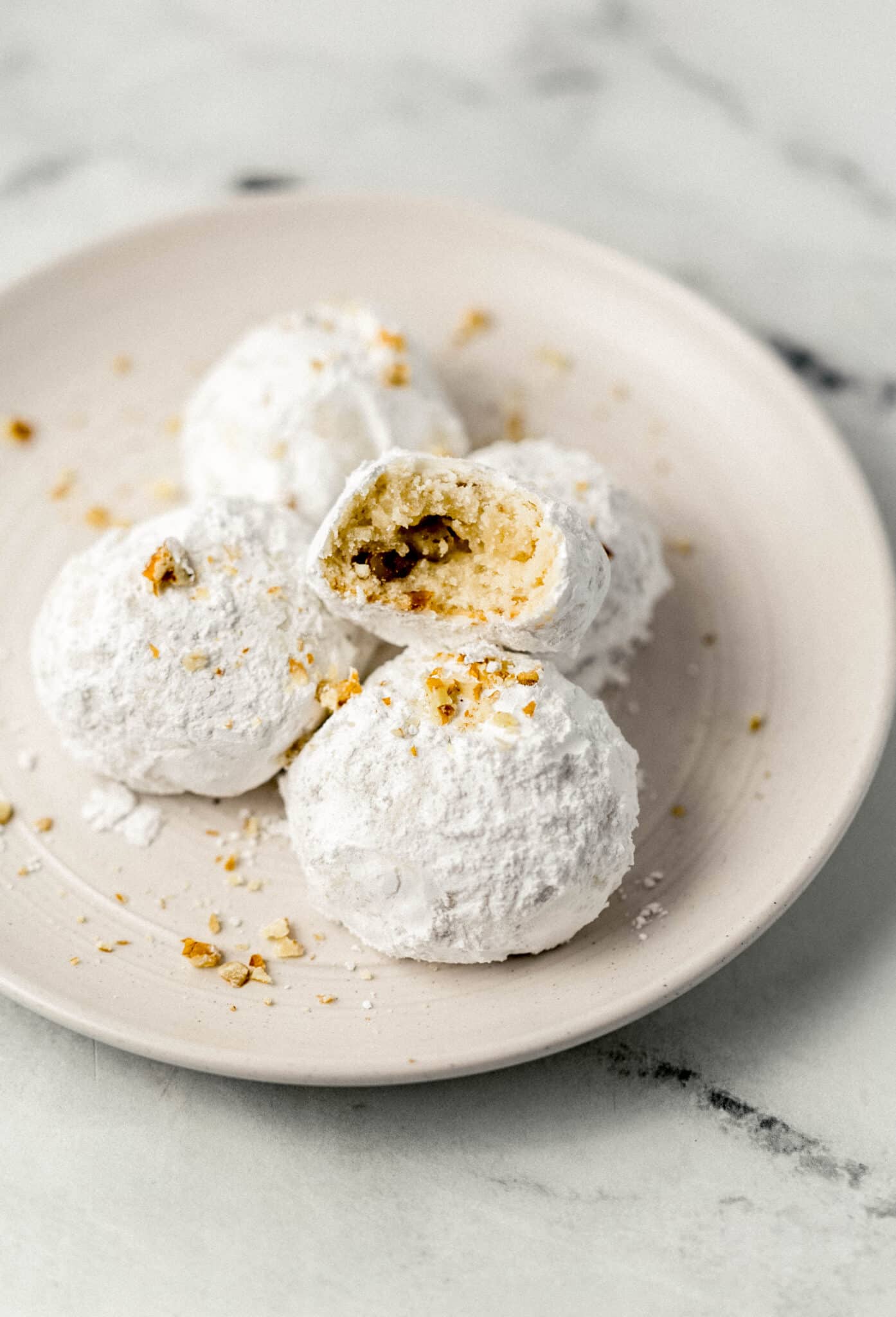 plate with tea cakes on it with a bite in one of them