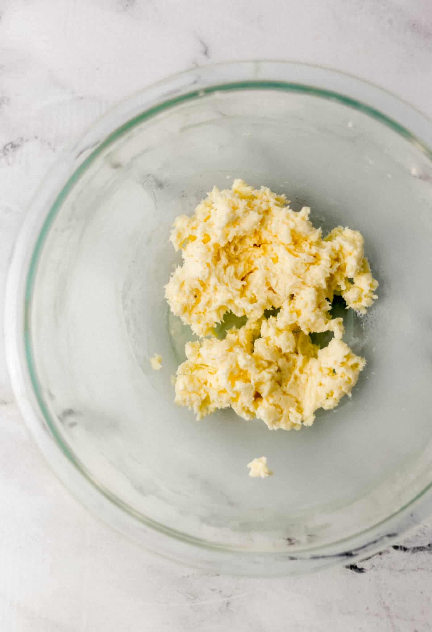 butter and powdered sugar combined in glass mixing bowl 