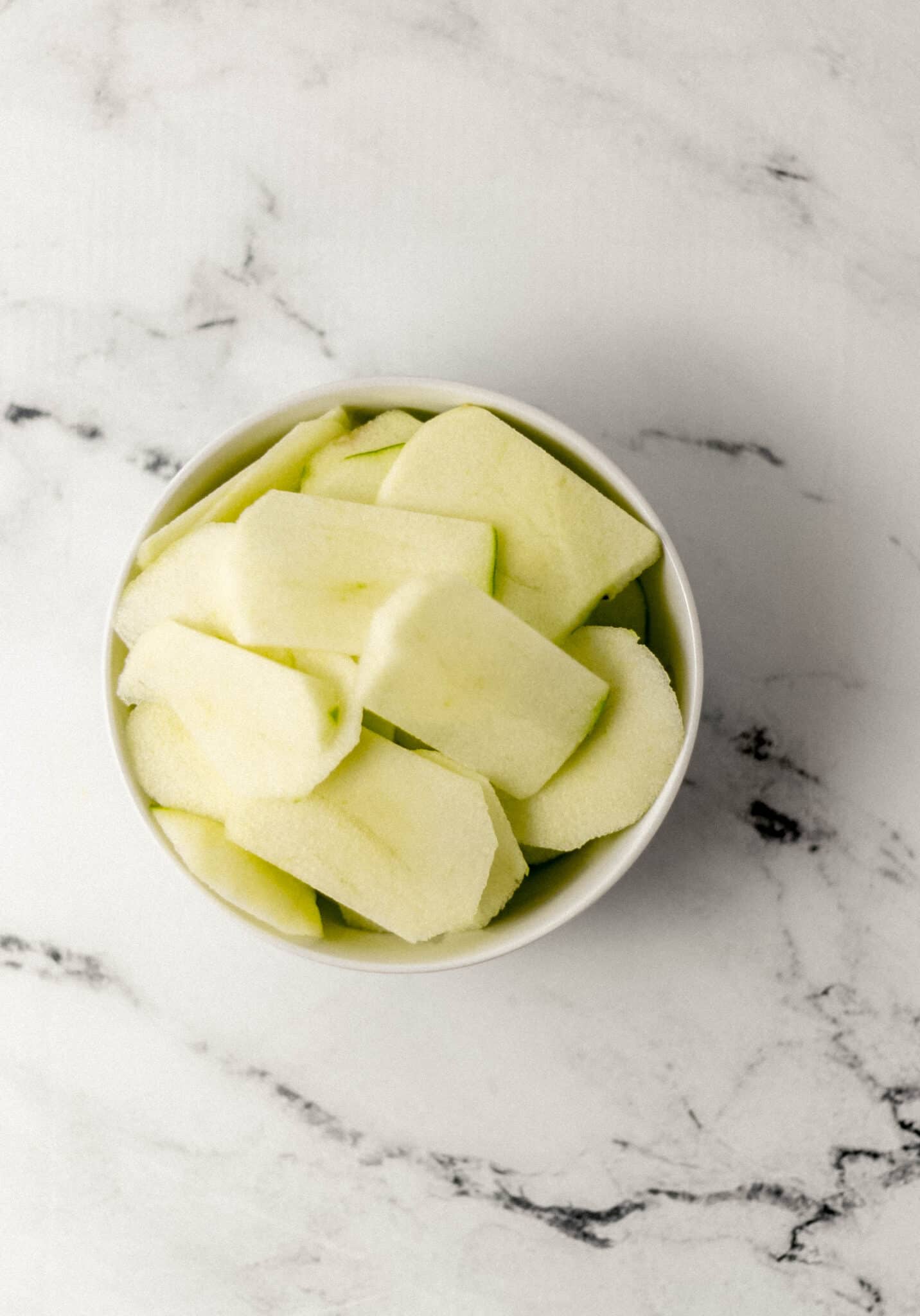 overhead view of apple slices in white bowl