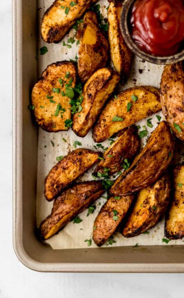 overhead view of baked potatoes on parchment lined baking sheet