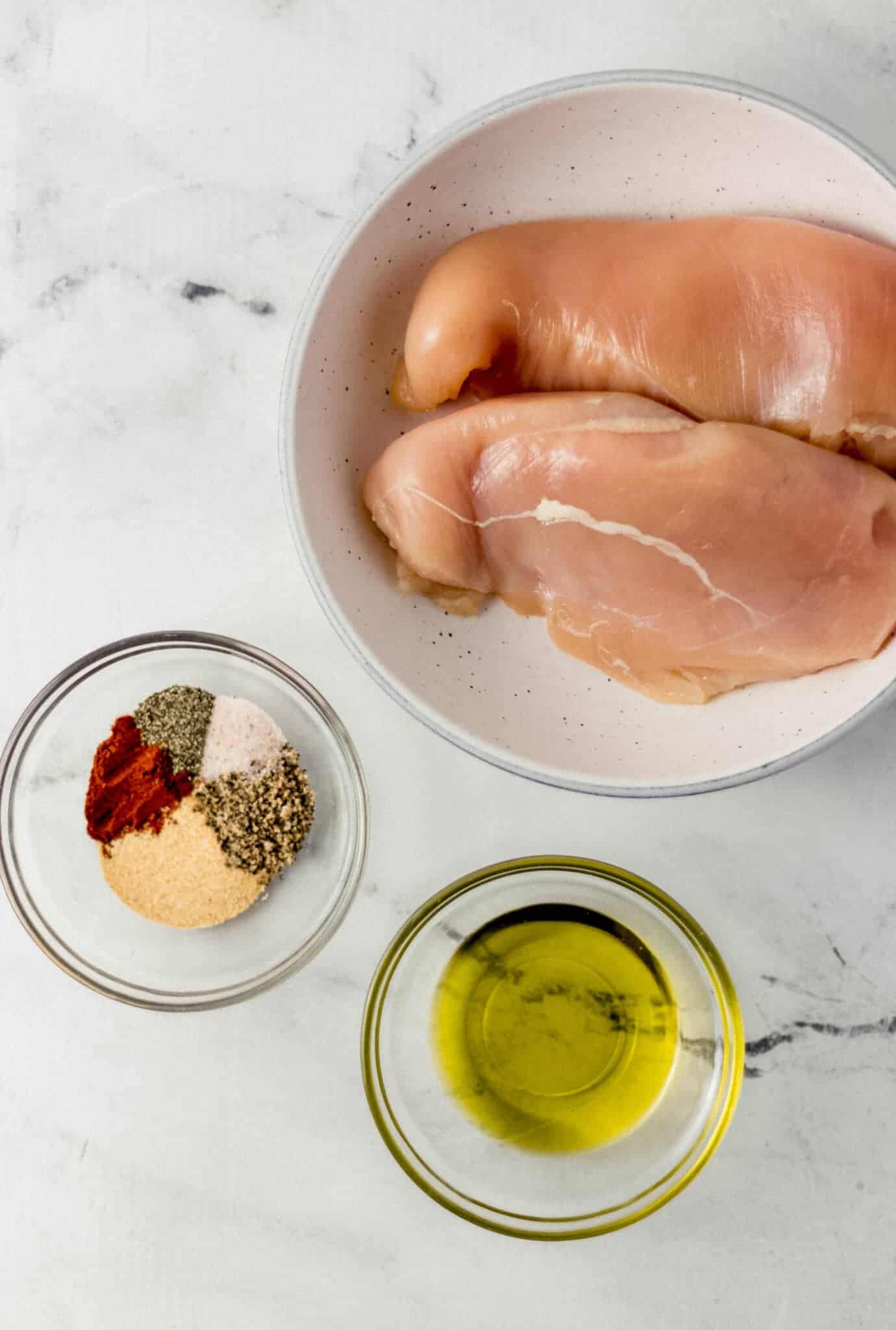 ingredients needed to make chicken breast in three separate bowls 