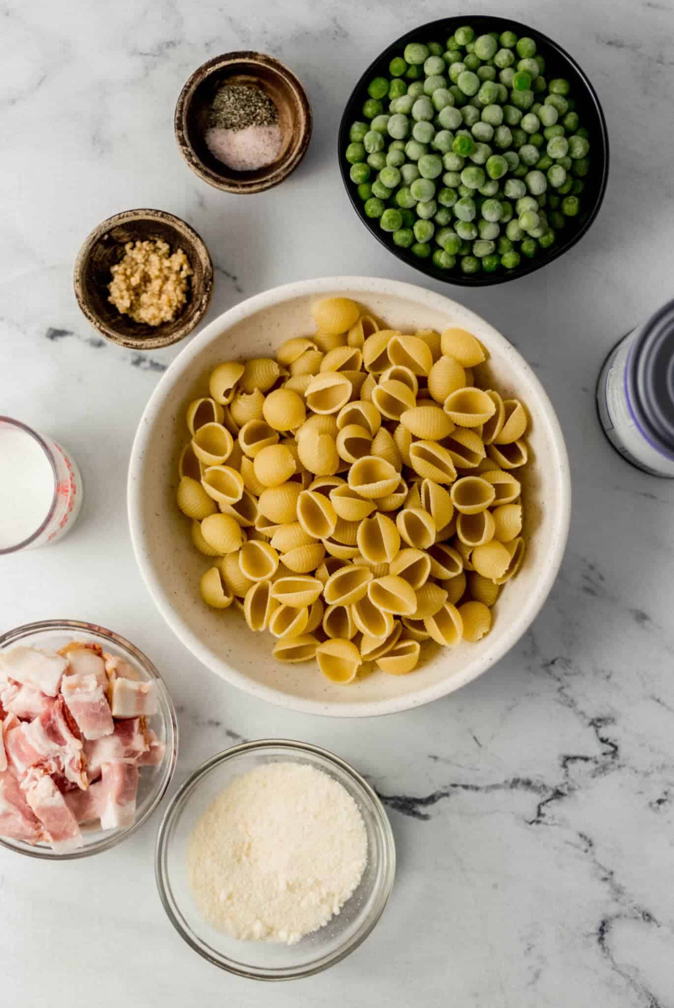 overhead view of ingredients needed to make pasta in separate bowls and containers