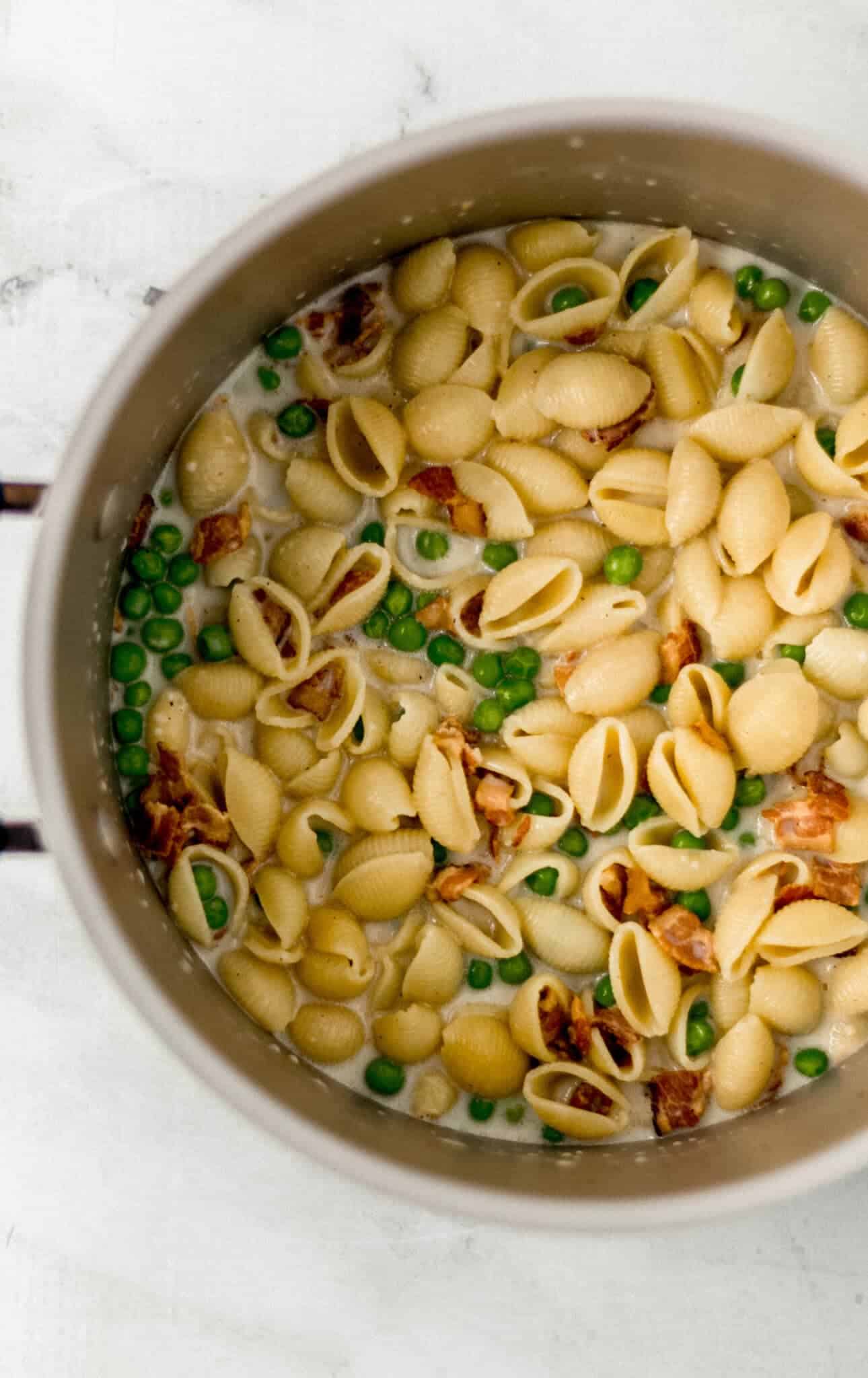 heavy cream, peas, and parmesan cheese added to the pot with the other pasta ingredients