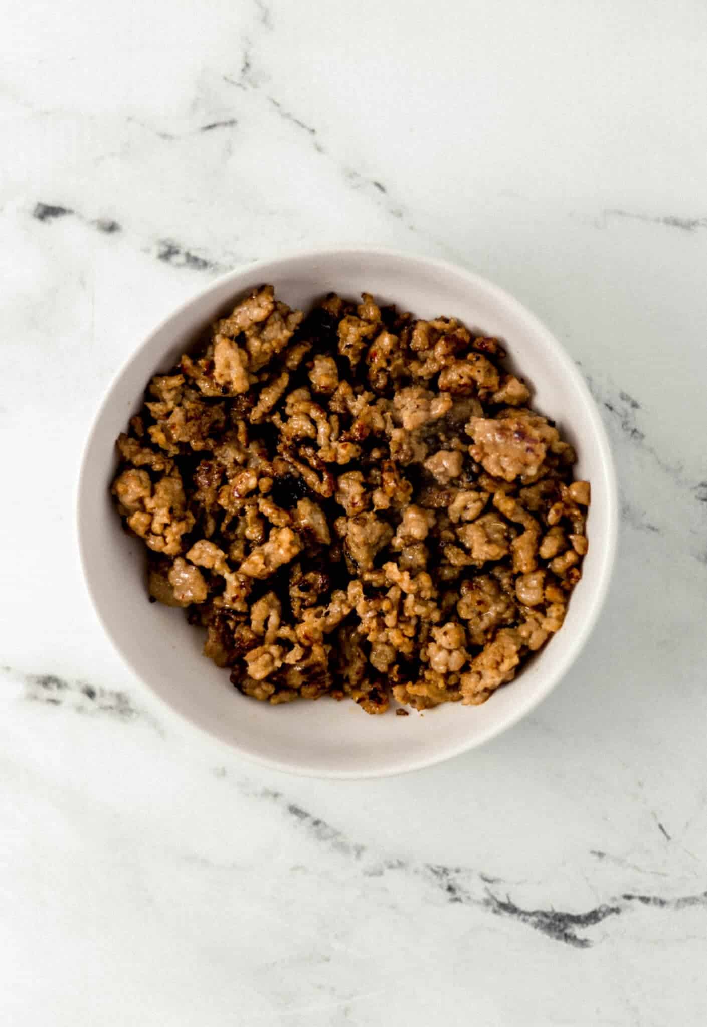 cooked ground sausage in white bowl
