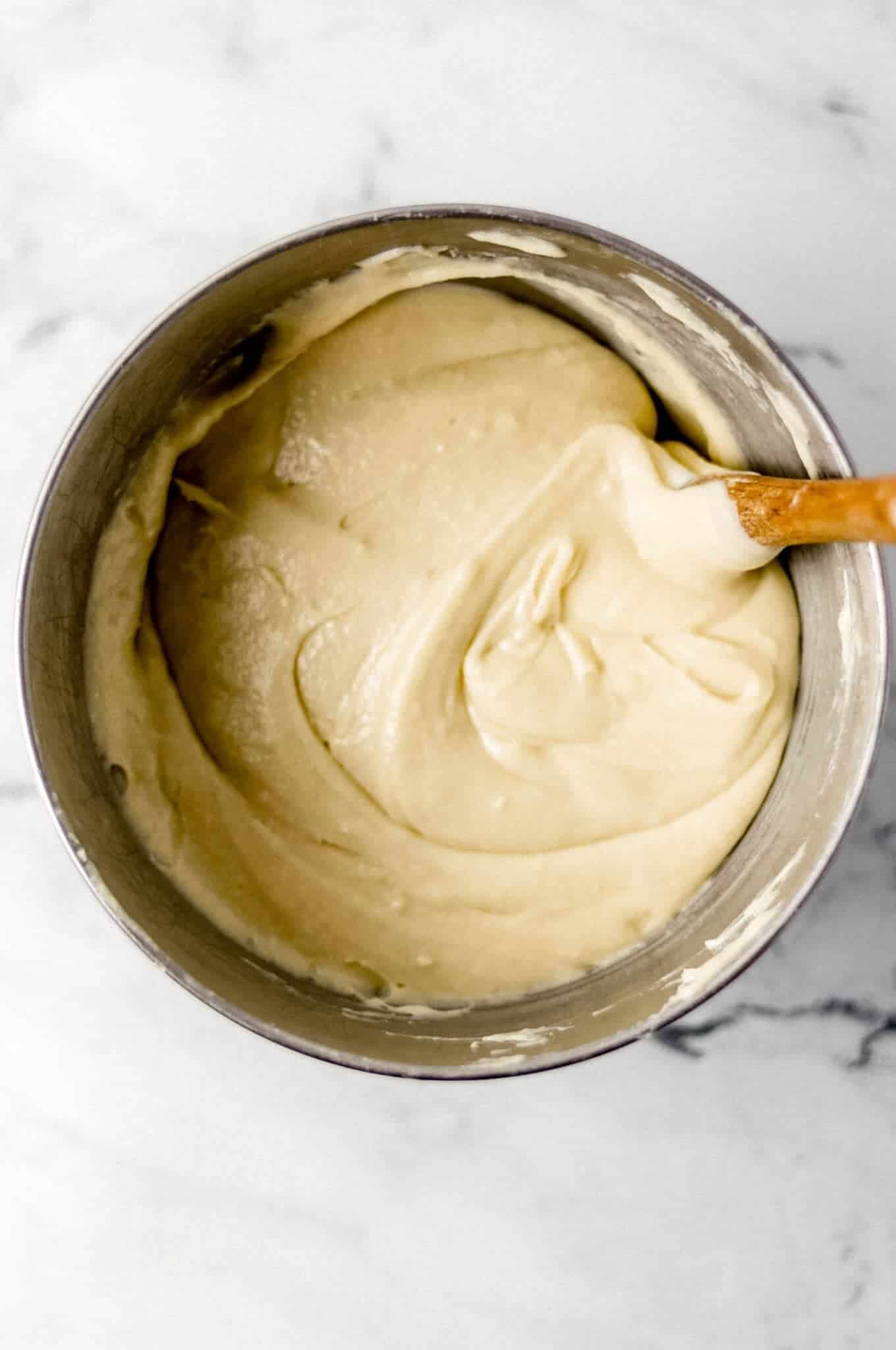 overhead view of pound cake mixture in stand mixer bowl with spatula in it.