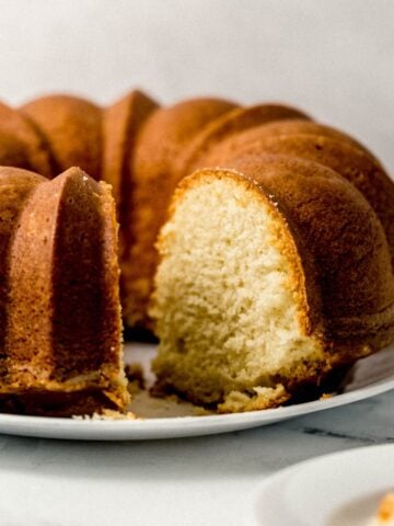 close up side view of finished pound cake with a slice cut out of it