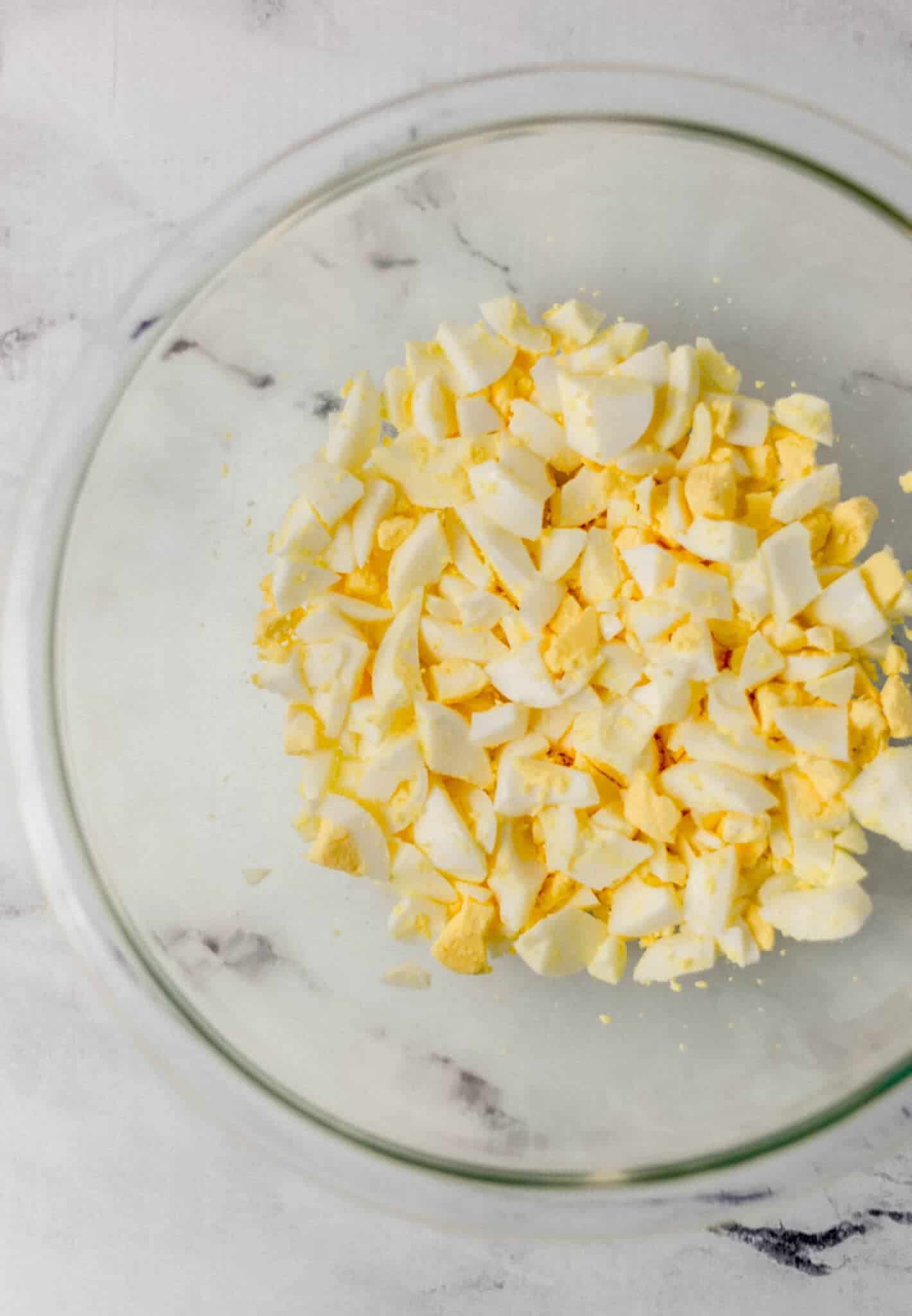 chopped up hard boiled eggs in glass bowl 