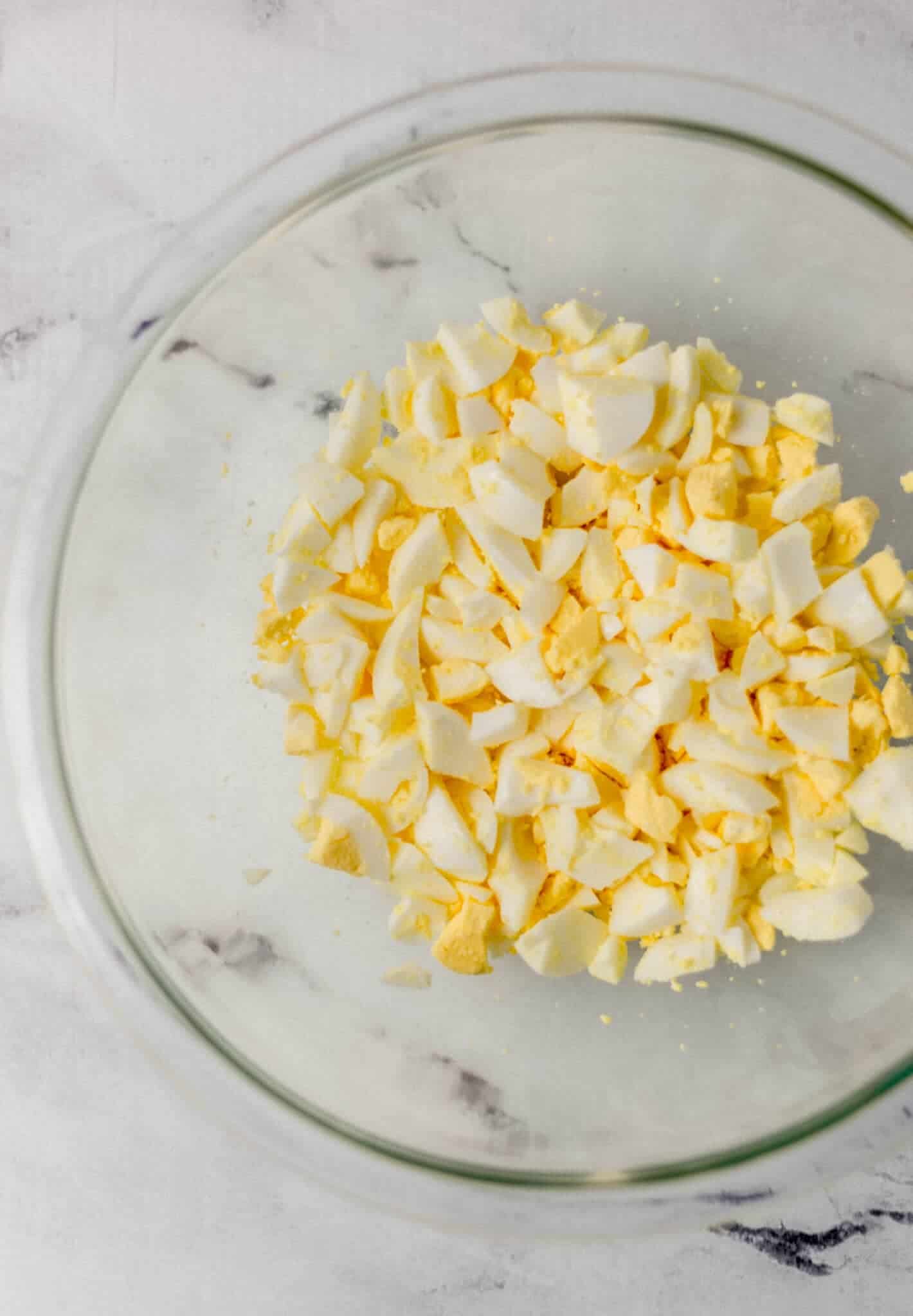 chopped up hard boiled eggs in glass bowl