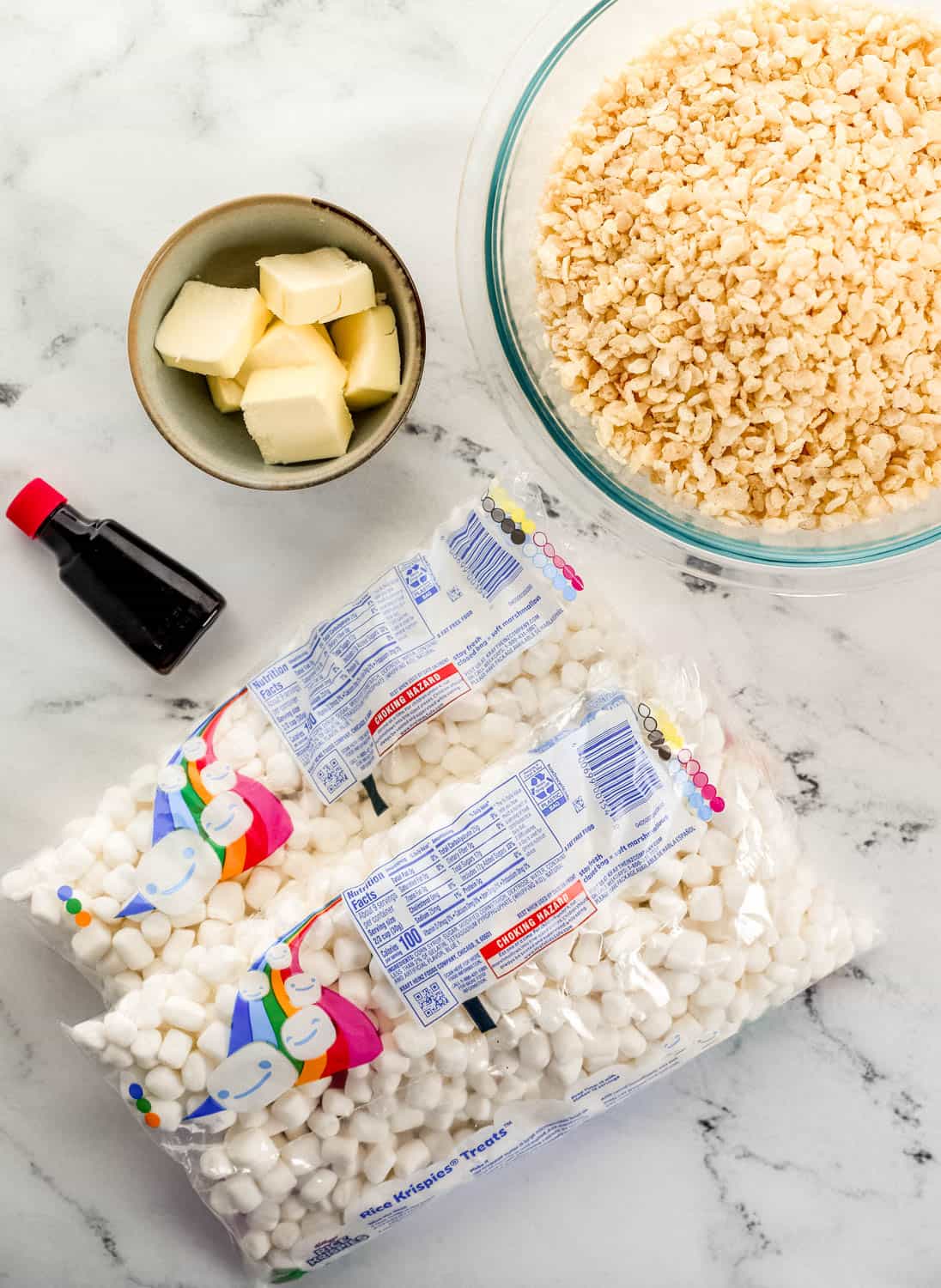Overhead view of ingredients needed to make rice krispie treat in separate bowls and packaging.