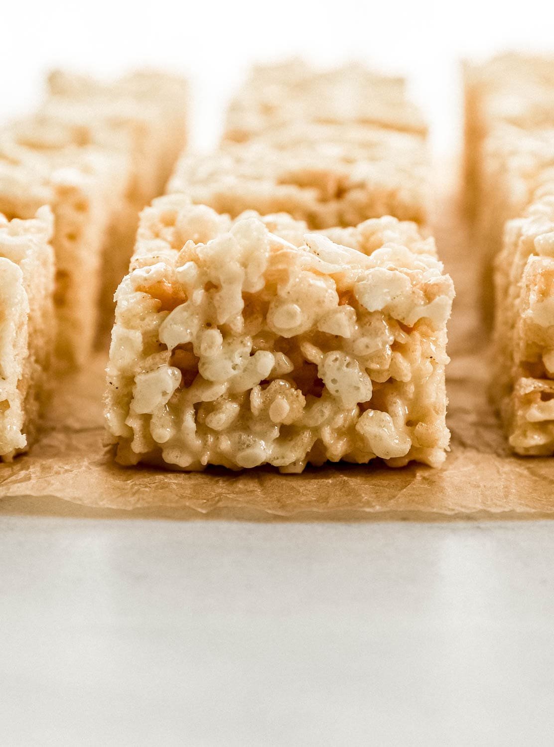 Close up side view of rice krispie treat on parchment paper.