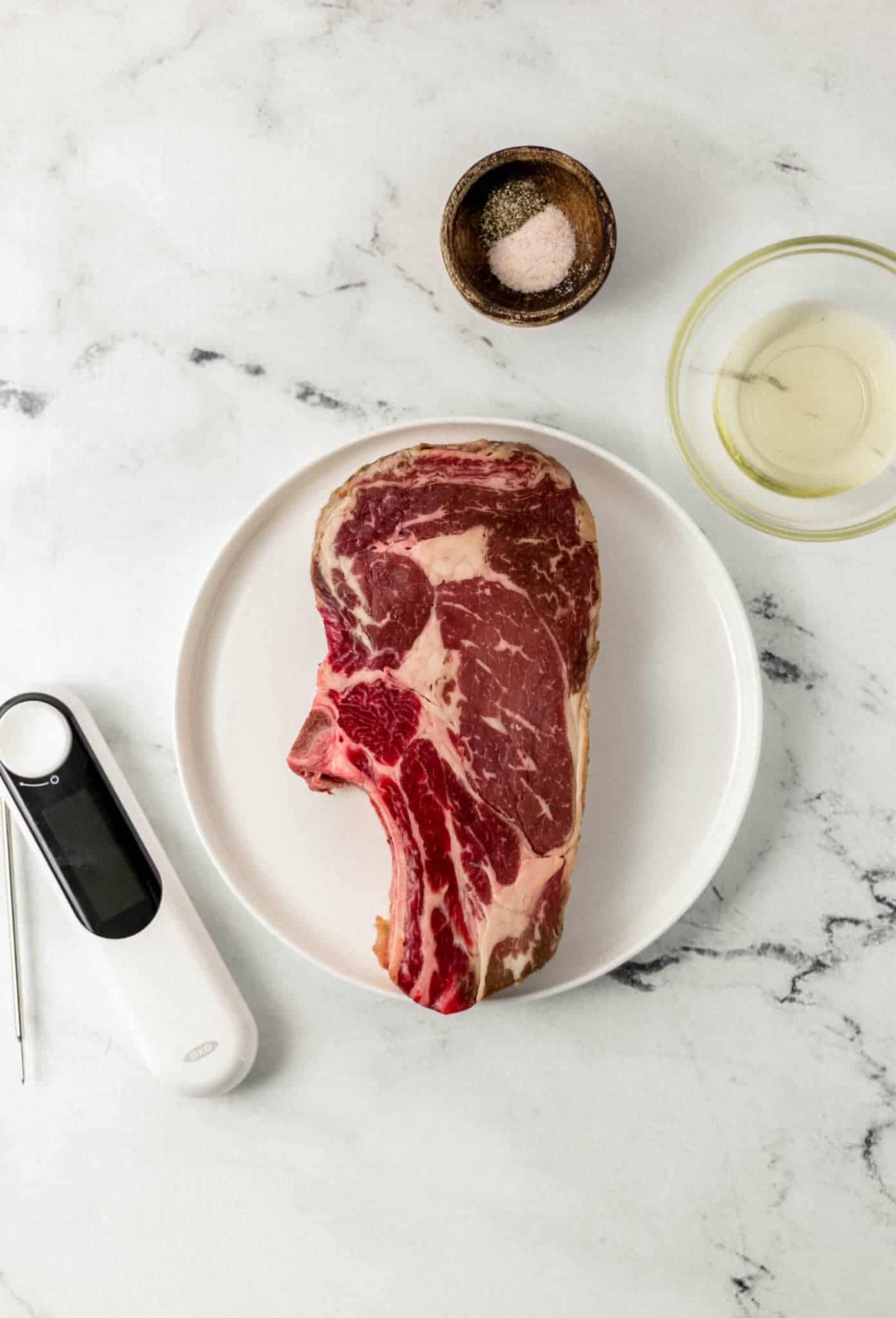 overhead view of ingredients needed to make steak recipe in separate plates and bowls 