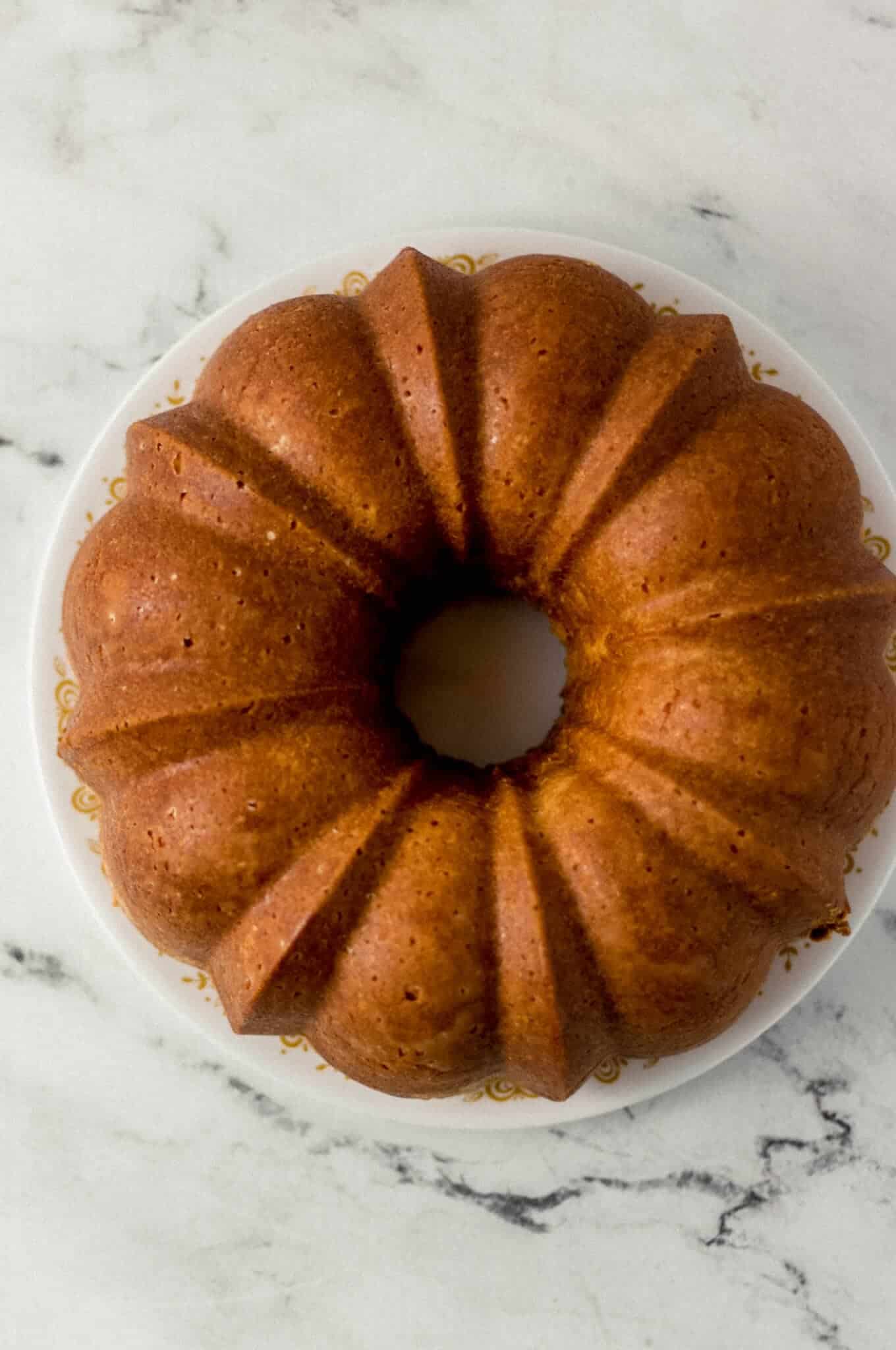 overhead view of finished pound cake removed from pan onto plate 