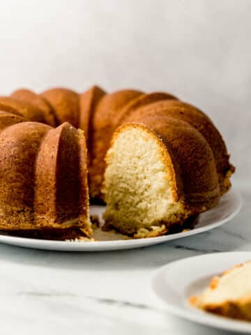 close up side view of finished pound cake with a slice cut out of it