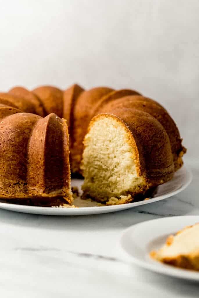 close up side view of finished pound cake with a slice cut out of it