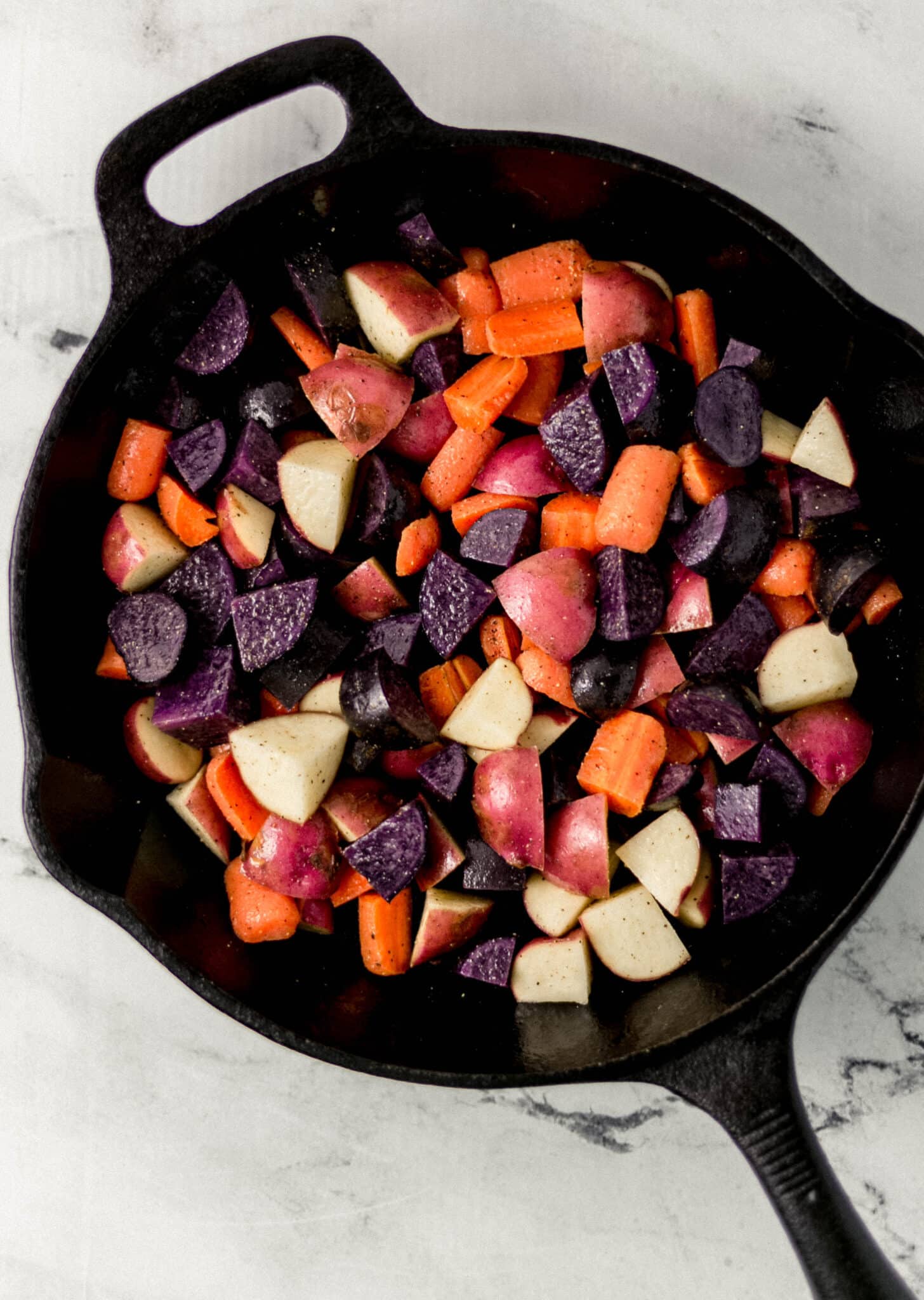 seasoned potatoes and carrots in cast iron skillet 