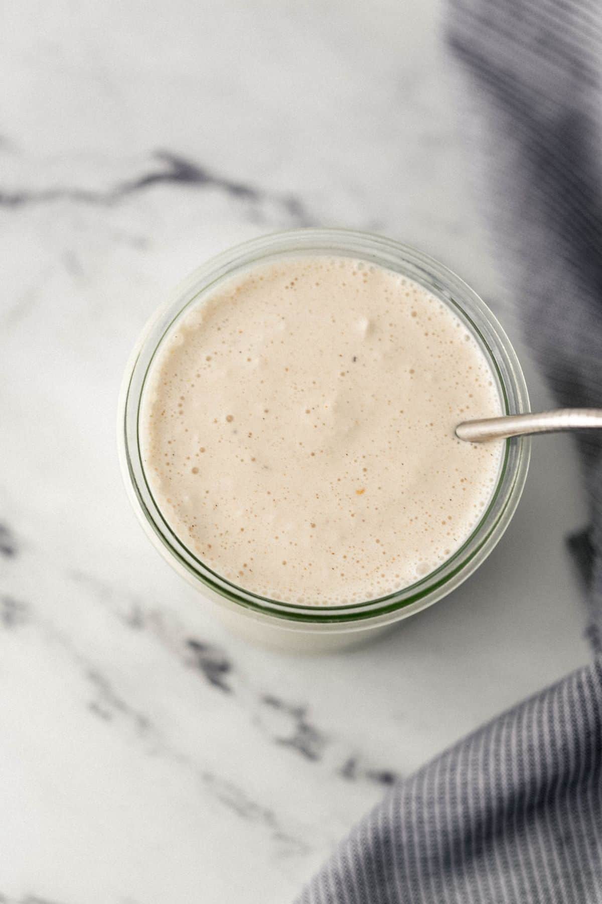 overhead view of finished milkshake in glass with straw in it