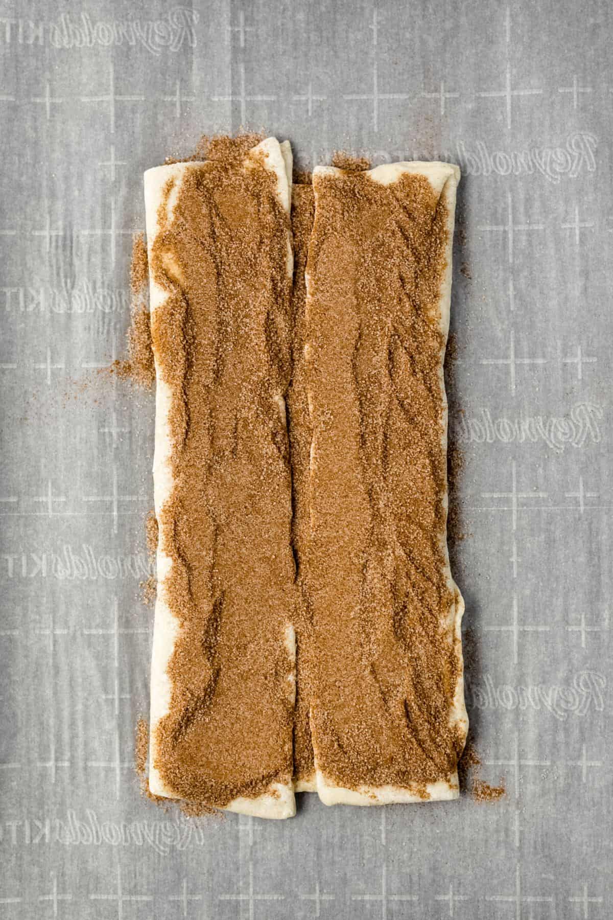 pastry topped with more cinnamon sugar on parchment lined baking sheet