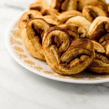 close up side view of finished elephant ears on large white plate