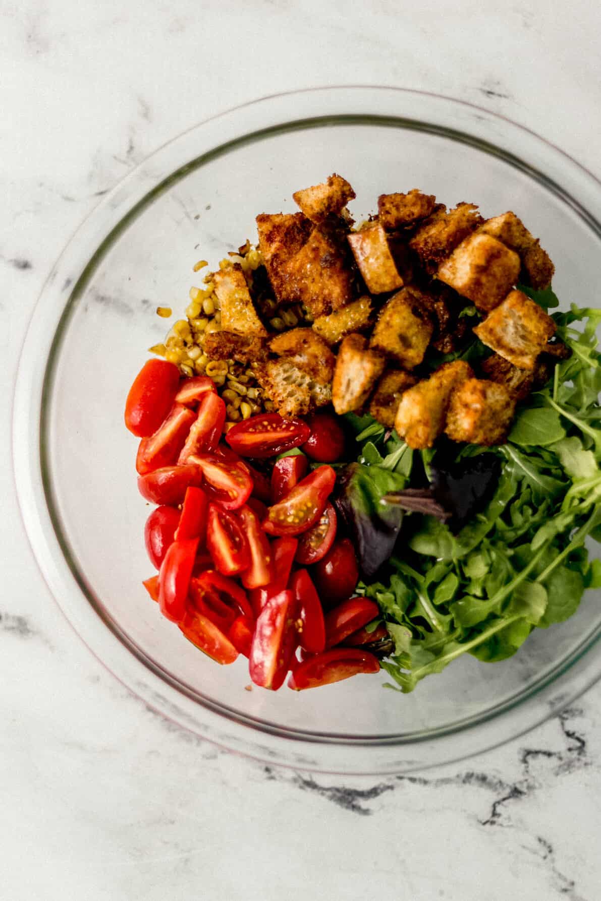 ingredients to make salad added to large glass bowl 